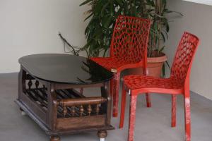 two chairs and a table and a table and two chairs at Aakruthi Homestay in Dāvangere