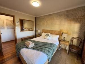 a bedroom with a bed and a table and a chair at Christophers Cottage in Bilpin