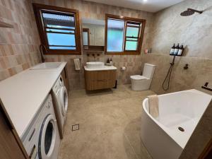 a bathroom with a sink and a washing machine at Christophers Cottage in Bilpin +11 photos