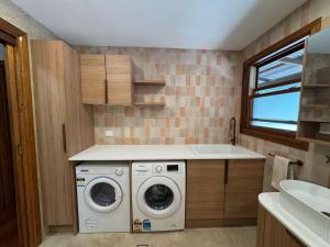 a laundry room with a washer and a sink at Christophers Cottage in Bilpin