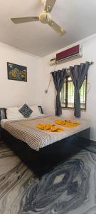a bedroom with a large bed with a ceiling fan at Morni Home's morjim in Morjim