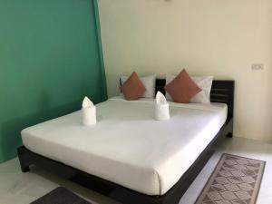 a bed with two pillows on it in a room at Lanta Vacation House in Ko Lanta +37 photos
