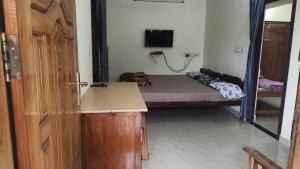 a room with a bed and a desk and a door at Munnar aathicottage in chinnakanal in Chinnakanal