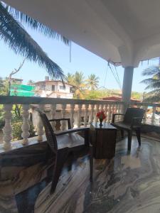 a porch with two chairs and a table on a balcony at Morni Home's morjim in Morjim +20 photos