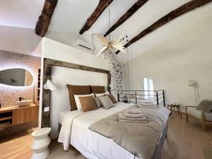 a bedroom with a large white bed and a bathroom at La Clède du PontNeuf in Valleraugue