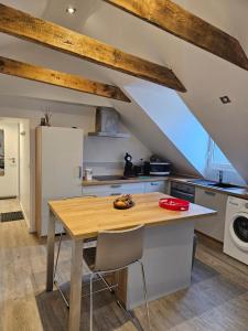 eine Küche mit Holztisch und Kühlschrank in der Unterkunft Le petit pierre in Quimper