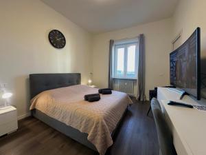 a bedroom with a bed and a clock on the wall at Suite Rossini - 100mq con parcheggio gratuito in Alessandria