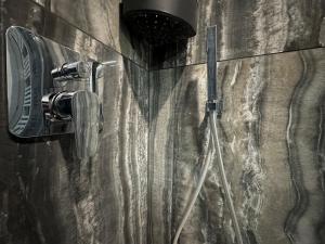 a shower with a shower head and a camera on a wall at Suite Rossini - 100mq con parcheggio gratuito in Alessandria +19 photos