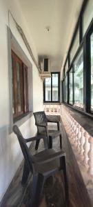 two black chairs sitting in a room with windows at Morni Home's morjim in Morjim