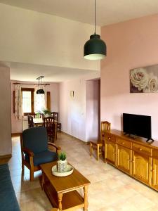 een woonkamer met een bank en een tv bij El Moral Centro de Turismo Rural in Valdecañas