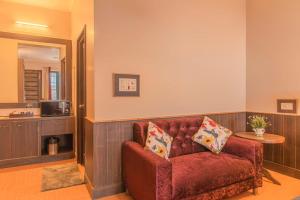 een woonkamer met een rode bank en een tafel bij The Horizon Villa Dharamshala in Dharmsala