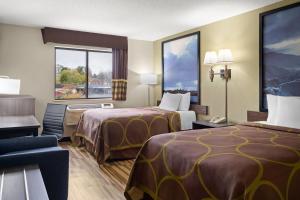 een hotelkamer met twee bedden en een bureau bij Super 8 by Wyndham Hagerstown I-70 in Hagerstown