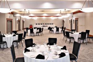 a banquet hall with white tables and chairs at Ramada by Wyndham Kelowna Hotel & Conference Center in Kelowna