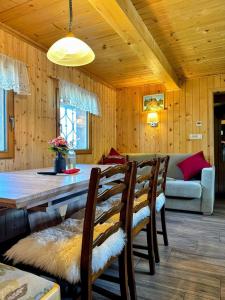 een woonkamer met een tafel, stoelen en een bank bij Koča Velika Planina - Chalet Kamrica in Stahovica
