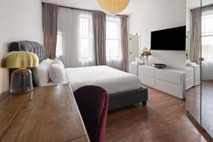 una camera da letto con un letto, una scrivania e una televisione di Hotel Brexton, Trademark Collection by Wyndham a Baltimora