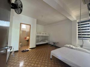 een slaapkamer met een bed en een kamer met een raam bij KNB West Villa Inn by SMS Hospitality in Bolinao +54 foto's