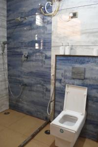 a bathroom with a toilet and a shower at Aakruthi Homestay in Dāvangere