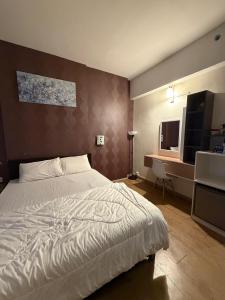 a bedroom with a white bed and a desk at Mikayla Suite in Kota Bharu +19 photos