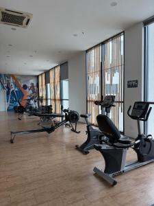 a gym with several treadmills and elliptical machines at Mikayla Suite in Kota Bharu