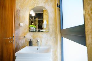 ein Badezimmer mit Waschbecken und Spiegel in der Unterkunft Hotel Fantazia Oradea - Self Check In & Out in Oradea + 106 Fotos