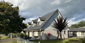 a white house with a black roof at Avero in Rotorua