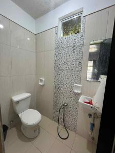 een badkamer met toilet en wastafel bij KNB West Villa Inn by SMS Hospitality in Bolinao