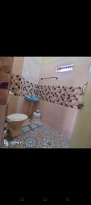 a bathroom with a toilet and a tile floor at M R ViLLA HAMPI magic rock villa in Hampi