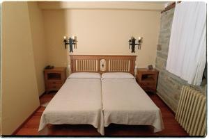 a bedroom with two beds and two crosses on the wall at Hotel Rural El Rincón de Trefacio in Trefacio