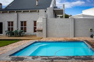 a swimming pool in front of a house at Joan's Sea Cottage in Pringle Bay