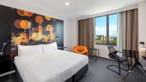 a hotel room with a bed and a desk at Flagstaff Gardens Hotel Melbourne in Melbourne