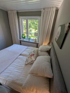 a bedroom with a bed with pillows and a window at Host Harmony 6 PP Cabin Close to lake in Vittsjö
