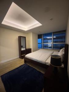 a bedroom with a bed and a large window at The Panoramic Centauras in Islamabad