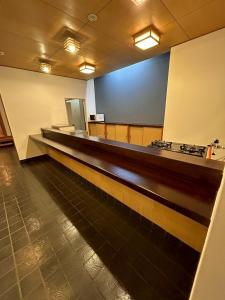 een wachtruimte met een lange balie in een gebouw bij 宿屋しの軒 1階 in Kirishima +1 foto