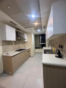 a large kitchen with a sink and a stove at The Panoramic Centauras in Islamabad
