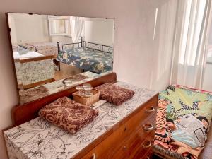 een slaapkamer met een dressoir en een spiegel bij L'ENCANTO DE LUNA -Una Casa Autentica Comacchiese in Comacchio