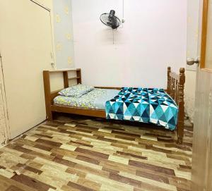 un piccolo letto in una camera con pavimento in legno di Budget Homestay Jelai a Gemas