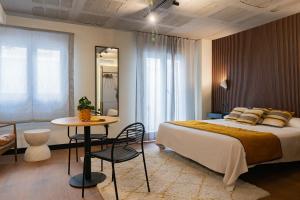 een slaapkamer met een groot bed en een tafel bij BUBU Apartments By Exclusive Homes in Málaga