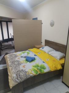 a bedroom with a bed with a yellow blanket at TREF 1 in Soko Banja