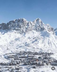 een met sneeuw bedekte berg met een stad ervoor bij Luxury Housing in Formigal in Formigal