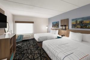 a hotel room with two beds and a flat screen tv at La Quinta by Wyndham Atlanta Roswell in Roswell +86 photos