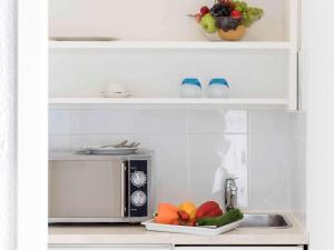 a kitchen with a microwave and a plate of fruit at Résidence Studio Genève Centre in Geneva