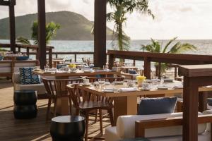ein Restaurant mit Tischen und Stühlen und Blick auf das Meer in der Unterkunft Park Hyatt St. Kitts in Christophe Harbour + 111 Fotos