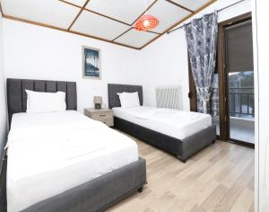 een slaapkamer met twee bedden en een raam bij Emily Apartment 5 in Chrysoupolis