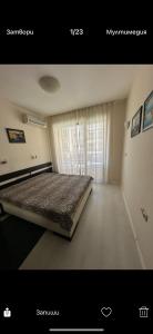 ein Schlafzimmer mit einem Bett in einem Zimmer mit Fenster in der Unterkunft Апартаменти Нино in Sozopol