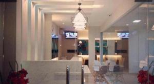 a lobby with tables and chairs in a building at Makassar Beach Inn in Makassar