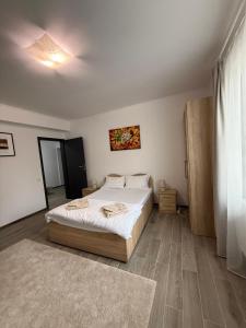 a bedroom with a large bed and a large window at Parlament Residence in Bucharest