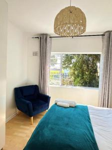 a bedroom with a blue bed and a blue chair at Lux City Haven in Cape Town