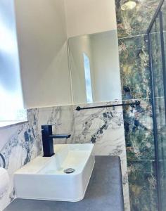 a bathroom with a sink and a mirror at Lux City Haven in Cape Town