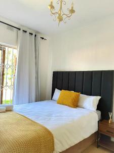 a bed with a black headboard in a bedroom at Lux City Haven in Cape Town +8 photos