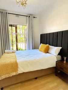 a bedroom with a large bed with a window at Lux City Haven in Cape Town